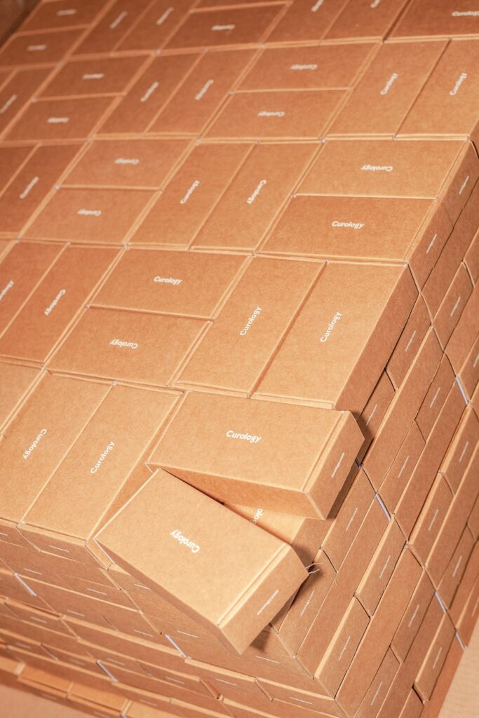 A person carefully packing a cardboard box with protective foam and sealing it with tape.