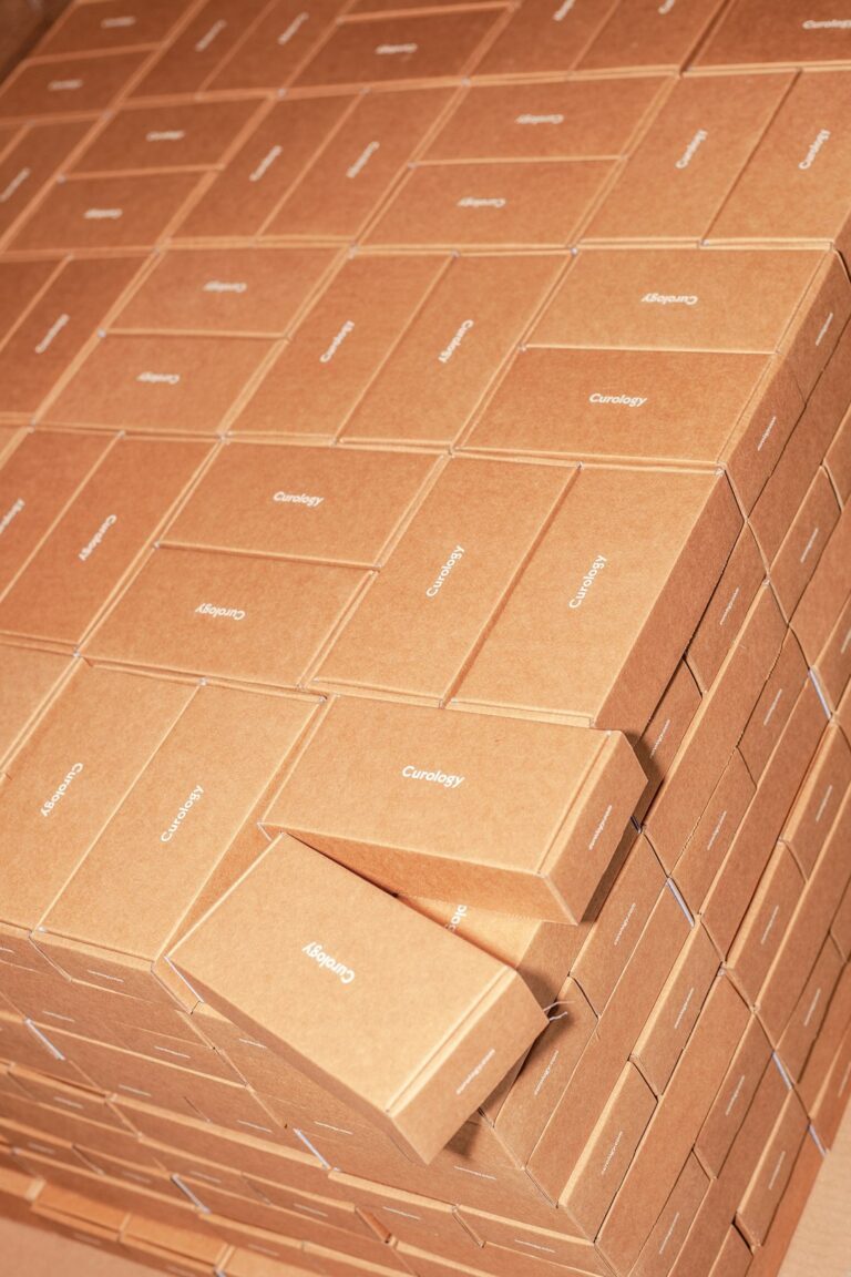 A person carefully packing a cardboard box with protective foam and sealing it with tape.